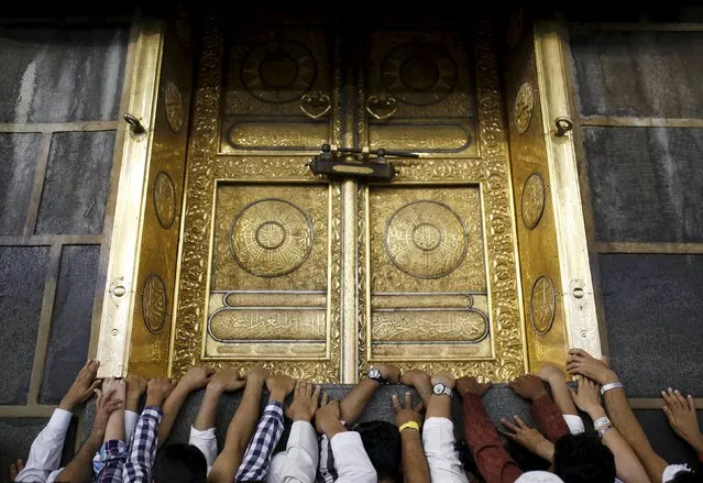 Muslim pilgrims touch the holy Kaaba at the Grand Mosque on the first day of Eid al-Adha during the annual haj pilgrimage in Mecca September 24, 2015. (Photo by Ahmad Masood/Reuters)