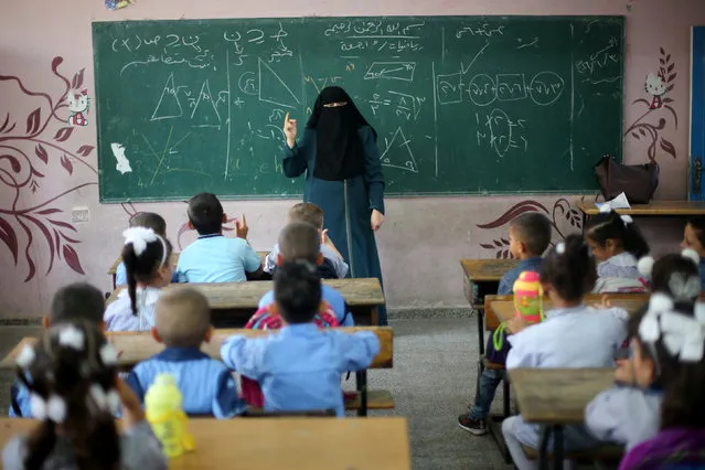 A veiled Palestinian teacher gives a mathematics lesson for schoolchildren in a classroom on the first day of a new school year, at a United Nations-run school in Khan Young in the southern Gaza Strip August 28, 2016. REUTERS/Ibraheem Abu Mustafa 