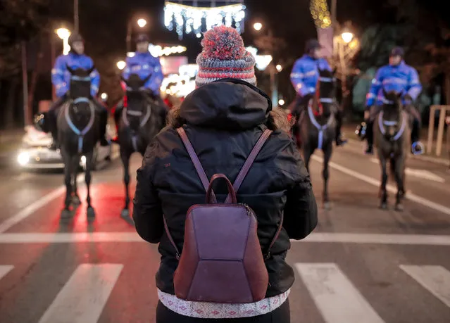 A girl stands in front of mounted riot policemen in Bucharest, Romania, Sunday, December 10, 2017. (Photo by Vadim Ghirda/AP Photo)