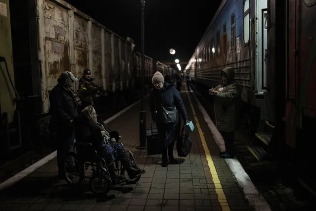 Ukrainians board the Kherson-Kyiv train at the Kherson railway station, southern Ukraine, Monday, November 21, 2022. Ukrainian authorities are evacuating civilians from recently liberated sections of the Kherson and Mykolaiv regions, fearing that a lack of heat, power and water due to Russian shelling will make conditions too unlivable this winter. The move came as rolling blackouts on Monday plagued most of the country. (Photo by Bernat Armangue/AP Photo)