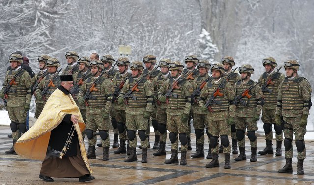 Paratroopers of the General Staff of the Land Forces are blessed by a military priest during a religious ceremony held in front of the Unknown Soldier Memorial to mark the 165th anniversary of the Unification of the Romanian Principalities, in Bucharest, Romania, 24 January 2024. The Day of the Unification of the Romanian Principalities, also known as the “Little Union Day”, is a public holiday of Romania that is celebrated every 24 January in order to commemorate the unification of the Romanian Principalities, performed on 24 January 1859 under the prince Alexandru Ioan Cuza. (Photo by Robert Ghement/EPA)
