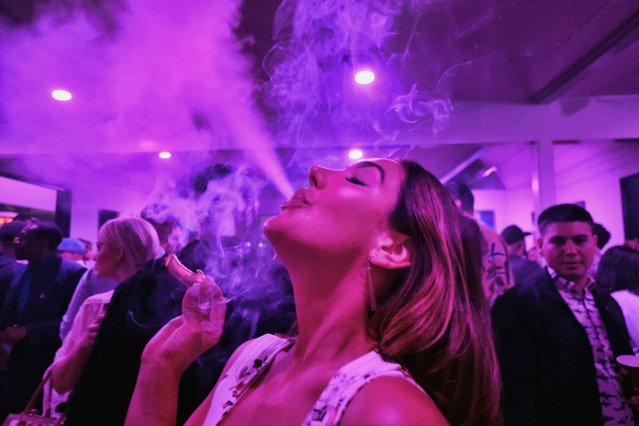 A guest takes a puff from a marijuana cigarette at the Sensi Magazine party celebrating the 420 holiday in the Bel Air section of Los Angeles on April 20, 2019. California lawmakers, on Tuesday, Aug. 30, 2022, approved a bill that would stop companies from punishing employees who use marijuana outside of work. Companies could still fire or discipline workers for using marijuana on the job or showing up to work while high. (Phoot by Richard Vogel/AP Photo)