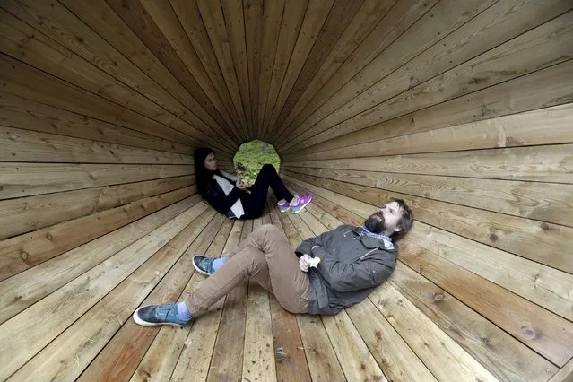 Head of the department of the interior architecture at Estonian Academy of Arts Hannes Praks (R) and student Birgit Oigus pose for a picture in the wooden megaphone in the forest near Pahni village, Estonia, September 28, 2015. (Photo by Ints Kalnins/Reuters)