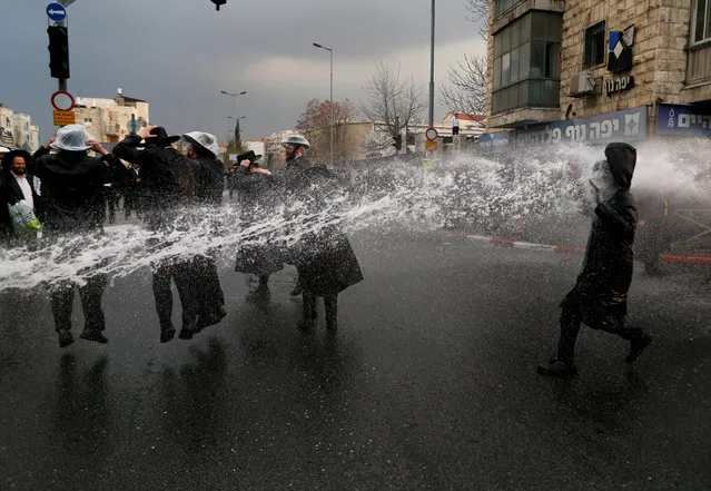 Ultra-Orthodox Jewish protestors are sprayed with water by Israeli police as they block a street during a demonstration against members of their community serving in the Israeli army, part of ongoing demonstrations recently seen throughout Israel, in Jerusalem, February 9, 2017. (Photo by Ammar Awad/Reuters)