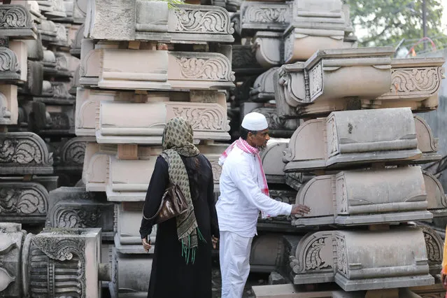 Indian Muslims look at pillars lying at a workshop for the construction of a Rama temple ahead of its groundbreaking ceremony in Ayodhya, in the Indian state of Uttar Pradesh, Monday, August 3, 2020. (Photo by Rajesh Kumar Singh/AP Photo)