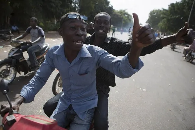 People gesture as they celebrate the departure of Burkina Faso's President Blaise Compaore in Ouagadougou, capital of Burkina Faso, October 31, 2014. (Photo by Joe Penney/Reuters)