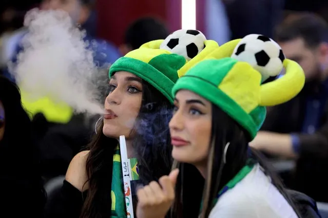 Lebanese women smoke nargileh (water pipe) and watch a streaming broadcast of the FIFA World Cup 2022 group G soccer match between Brazil and Switzerland, at a café-restaurant in the area of Sabtiyeh, north of Beirut, on November 28, 2022. Lebanon being hit hard by the economic crisis, the country did not obtain the rights to broadcast the 2022 World Cup this year, depriving Lebanese fans of the World Cup. (Photo by Joseph Eid/AFP Photo)