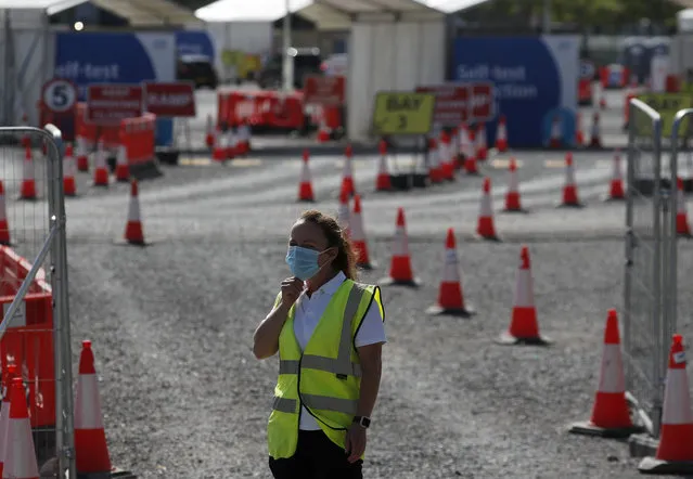 Staff waits in front of empty lanes of a Covid-19 drive thru testing facility at Twickenham stadium in London, Thursday, September 17, 2020. Britain has imposed tougher restrictions on people and businesses in parts of northeastern England on Thursday as the nation attempts to stem the spread of COVID-19, although some testing facilities remain under-utilised. (Photo by Frank Augstein/AP Photo)