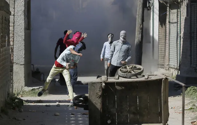 Kashmiri Muslim protesters throw stones at government forces in Srinagar, Indian controlled Kashmir, Friday, September 23, 2016. (Photo by Mukhtar Khan/AP Photo)