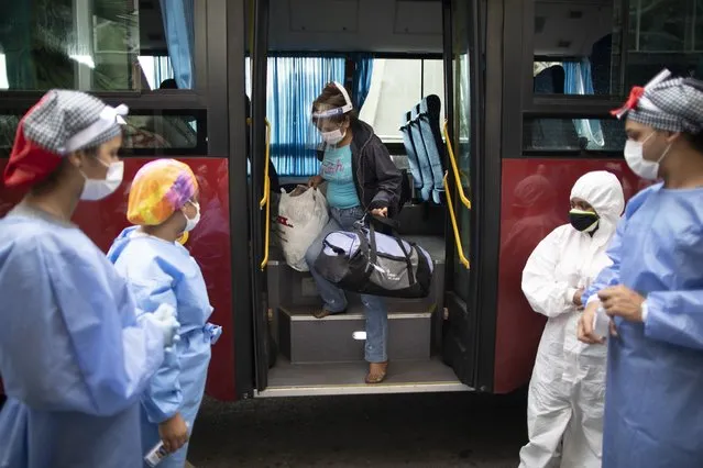 A woman who tested positive for COVID-19 arrives on a government bus to a former students residence being used to quarantine asymptomatic patients infected with the new coronavirus in Caracas, Venezuela, Tuesday, Aug 25, 2020. (Photo by Ariana Cubillos/AP Photo)