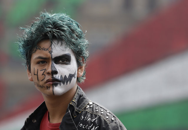 A protestor with a painted face participates in a march commemorating the anniversary of the Tlatelolco Massacre, in Mexico City, Sunday, October 2, 2016. Every year Mexico marks the anniversary of the 1968 massacre where students and civilians were killed by the military and police. (Photo by Rebecca Blackwell/AP Photo)