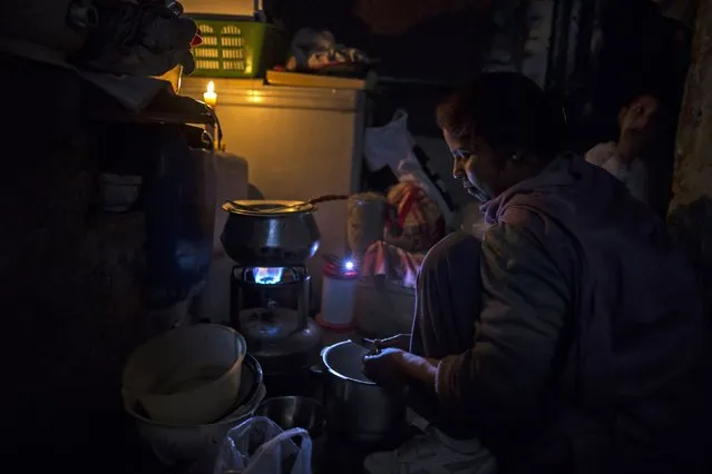 A woman cooks during a power shortage at her house at a Christian slum in Islamabad December 4, 2014. (Photo by Zohra Bensemra/Reuters)