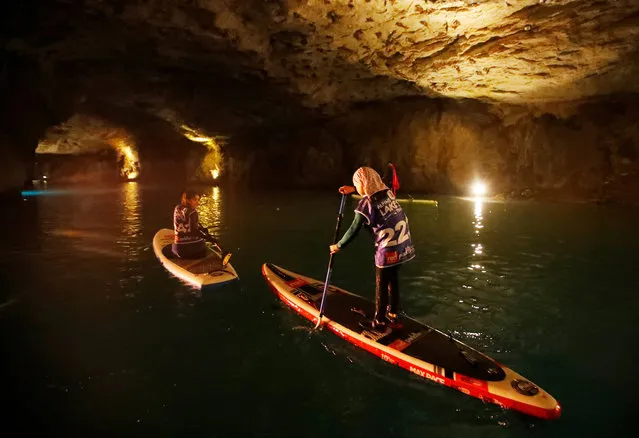 A mother and her daughter paddle during a Stand Up Paddle (SUP) race of the Alpine Lakes Tour, on Europe's biggest underground lake, in St-Leonard, Switzerland, March 10, 2018. (Photo by Denis Balibouse/Reuters)