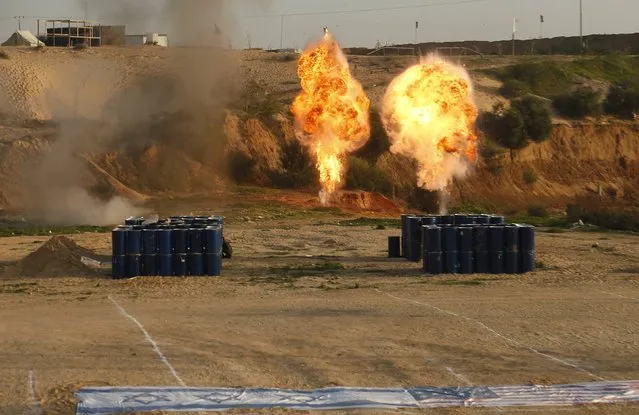 Explosions are seen as the national flags of Israel (front L) and the U.S. are placed on the ground during a military drill by Palestinian Islamic Jihad militants in the southern Gaza Strip December 11, 2014. (Photo by Suhaib Salem/Reuters)