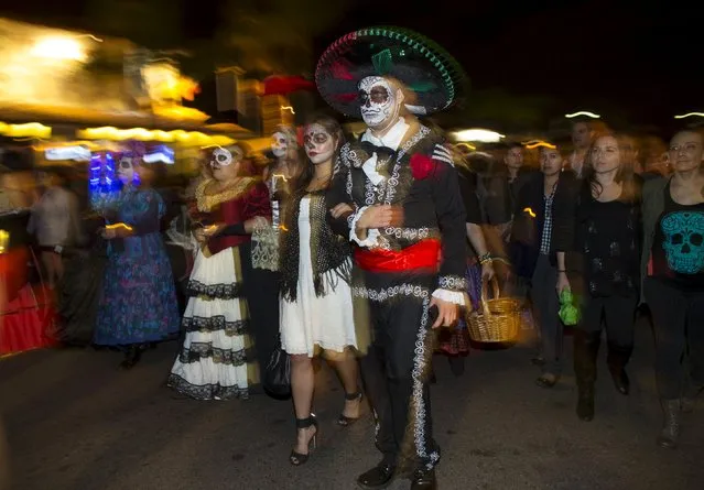 Participants march during a candlelight procession at the end of a three-day "Day of The Dead" (Dia de los Muertos) celebration, which saw hundreds walk to El Campo Santo cemetery, in Old Town San Diego, California, November 2, 2015. (Photo by Mike Blake/Reuters)