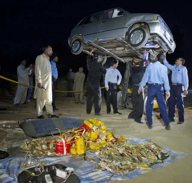 Pakistani police officers and explosive experts examine a car parked near the house of Pakistan's former President military ruler Pervez Musharraf, in Islamabad, Pakistan on Tuesday, April 23, 2013. Islamabad police chief Bani Amin says the explosive-laden vehicle was found parked about 150 meters (500 feet) from the main gate of Musharraf's house on the capital's outskirts Tuesday. (Photo by B. K. Bangash/AP Photo)