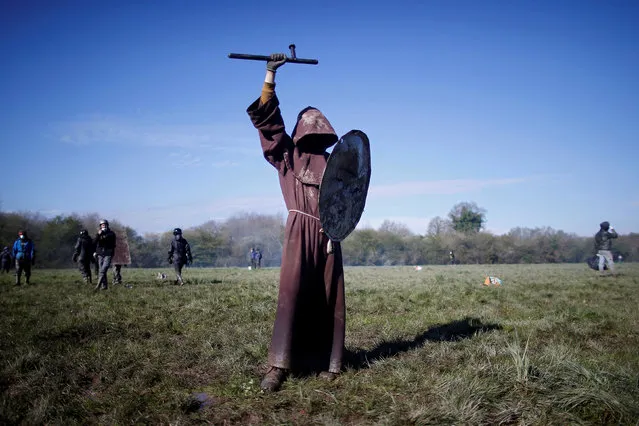 A protester holds a French gendarme's baton and shield during the evacuation operation in the zoned ZAD (Deferred Development Zone) at Notre-Dame-des-Landes, near Nantes, France, April 11, 2018. (Photo by Stephane Mahe/Reuters)