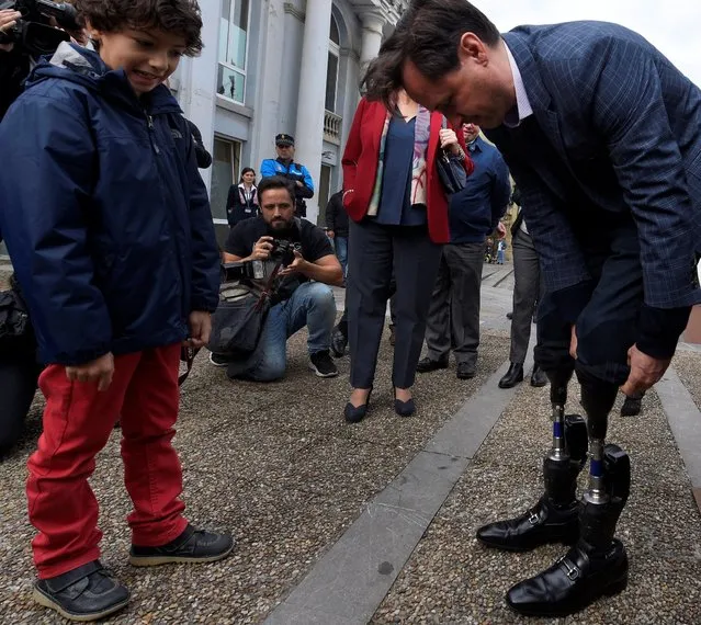 U.S. physicist Hugh Herr, recipient of the 2016 Princess of Asturias Award for Technical and Scientific Research, shows to the children his bionic legs during an exhibition of children's drawings dedicated to him in Aviles, Spain, October 18, 2016. (Photo by Eloy Alonso/Reuters)