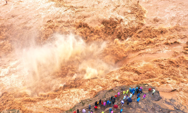 Aerial view of tourists visiting the roaring Hukou Waterfall on the Yellow River on October 12, 2025 in Jixian County, Linfen City, Shanxi Province of China. (Photo by Lyu Guiming/VCG via Getty Images)