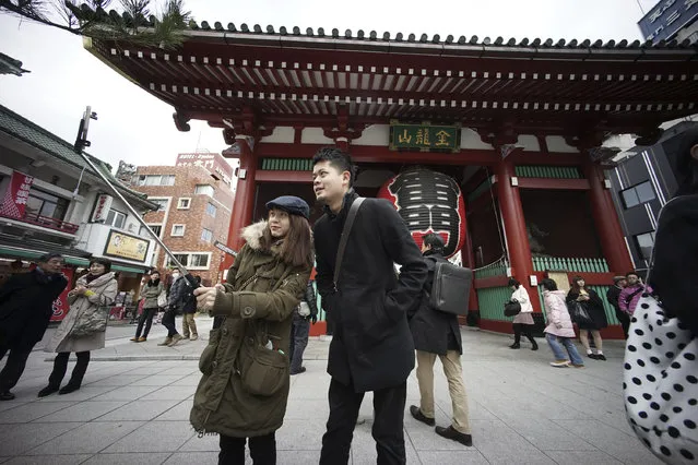 Huang Hsin, left, and Lu Yz-che, right, from Taiwan take a photo with selfie stick at the gate of Sensoji temple in Asakusa District in Tokyo Wednesday, January 7, 2015. Selfie sticks have become popular among tourists because you don't have to ask strangers to take your picture, and you can capture a wide view in a selfie without showing your arm. But some people find selfie sticks obnoxious, arguing that they detract from the travel experience. (Photo by Eugene Hoshiko/AP Photo)
