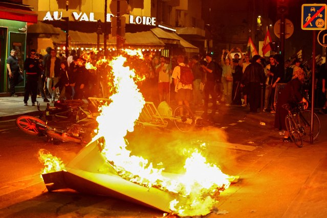A barricade burns as protesters demonstrate against the French far-right Rassemblement National (National Rally - RN) party, following partial results in the first round of the early 2024 legislative elections, at the Place de la Republique in Paris, France, on July 1, 2024. (Photo by Fabrizio Bensch/Reuters)