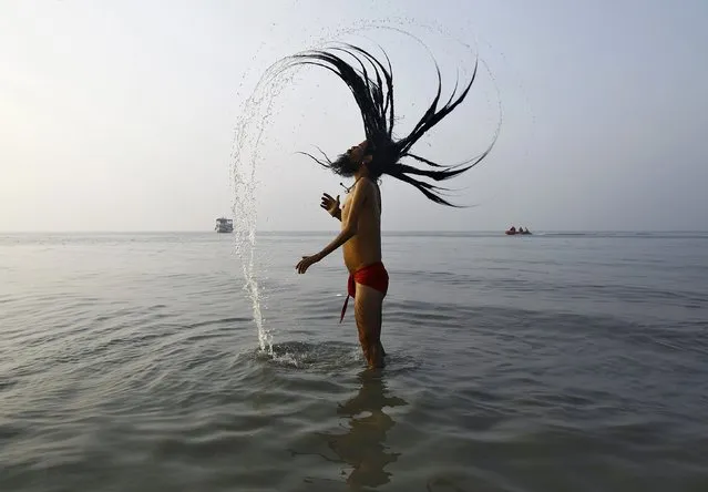 A “Sadhu”, or a Hindu holy man, takes a dip at the confluence of the river Ganges and the Bay of Bengal, ahead of the “Makar Sankranti” festival at Sagar Island, south of Kolkata January 13, 2015. Hindu monks and pilgrims are making their annual trip to Sagar Island for the one-day festival of “Makar Sankranti” on Wednesday. (Photo by Rupak De Chowdhuri/Reuters)