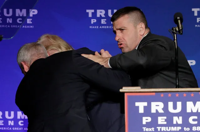 Secret Service agents rush Republican presidential candidate Donald Trump off the stage during a campaign rally in Reno, Nev., on Saturday, November 5, 2016. He returned to the podium afterwards. (Photo by John Locher/AP Photo)