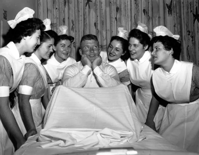 Yankee center fielder Mickey Mantle is the center of attraction before undergoing a tonsilectomy at Lenox Hill Hospital in New York on January 17, 1956. The nurses, from left to right, are: Eleanor Hoffman, Catherine Craig, Maureen Kade, Kim Crocker, Ann Koch, and Anita Edwards. (Photo by AP Photo)