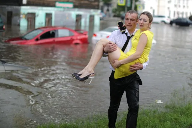 A woman is rescued from a car after a flash flood in Nizhny Novgorod, Russia on June 19, 2018. (Photo by Lucy Nicholson/Reuters)