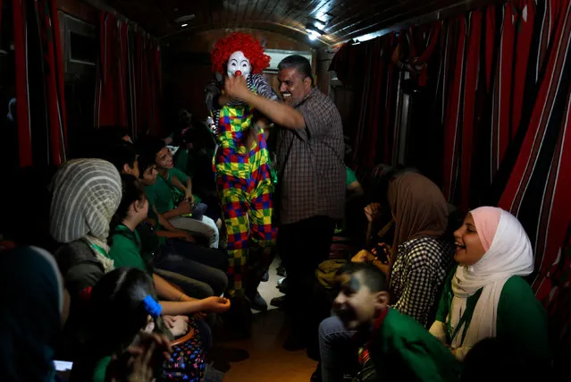 Activists and their families celebrate with orphans after their meals for iftar on a train trip in Amman, Jordan, May 31, 2018. (Photo by Muhammad Hamed/Reuters)