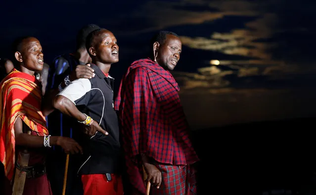 Maasai tribesmen queue to use a telescope to watch the skies as they prepare to witness the rise of the supermoon (seen partially obscured behind) in Oloika village in Shompole, Magadi near the Kenya-Tanzanian border, November 14, 2016. (Photo by Thomas Mukoya/Reuters)