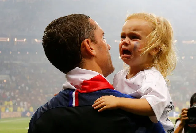France' s forward Antoine Griezmann carries his daughter, Mia, as he celebrates after the Russia 2018 World Cup final football match between France and Croatia at the Luzhniki Stadium in Moscow on July 15, 2018. (Photo by Darren Staples/Reuters)