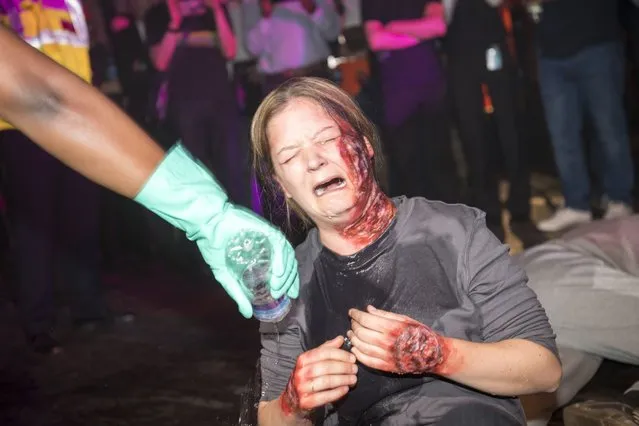 Emergency services staged a simulated acid attack inside a Heaven Nightclub in London, England on July 18, 2018, to prepare for if it really happened. Photo shows how “victims” were doused with water by staff to wash off the corrosive substance. During the simulation,a man in a balaclava sprayed a bottle of acid, injuring ten people. (Photo by i-Images Picture Agency)