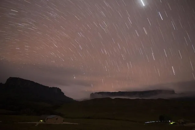 Stars are seen in the night sky over Kukenan (L) and Roraima mounts near the Tec Camp, near Venezuela's border with Brazil January 14, 2015. (Photo by Carlos Garcia Rawlins/Reuters)