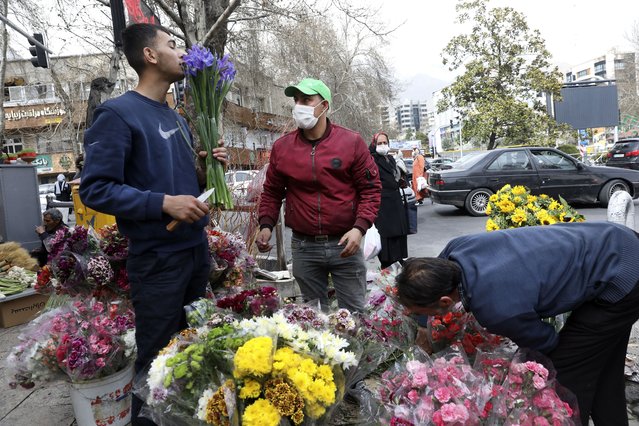 Flower sellers arrange their flowers ahead of the Persian New Year, or Nowruz, meaning “New Day” in northern Tajrish Square, Tehran, Iran, Monday, March 15, 2021. (Photo by Vahid Salemi/AP Photo)