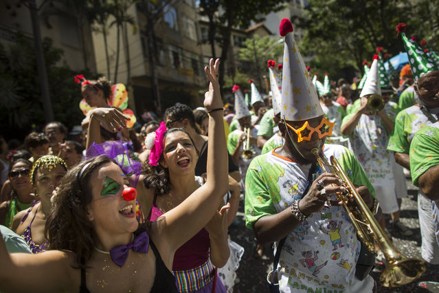 Revelers dance as musicians perform during the “Gigantes da Lira” carnival parade in Rio de Janeiro, Brazil, Sunday, February 8, 2015. (Photo by Felipe Dana/AP Photo)