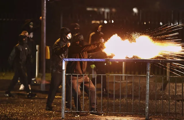 Youths fire fireworks at the PSNI on the Springfield road, during further unrest in Belfast, Northern Ireland, Thursday, April 8, 2021. Police and politicians in Northern Ireland have appealed for calm after a third night of violence that saw Protestant youths start fires and pelt officers with bricks and gasoline bombs. The flareups come amid rising tensions over post-Brexit trade rules for Northern Ireland and worsening relations between the parties in the Protestant-Catholic power-sharing Belfast government. (Photo by Liam McBurney/PA Wire via AP Photo)