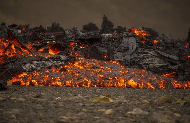 Lava flows from a new fissure on a volcano on the Reykjanes Peninsula in southwestern Iceland, Monday, April 5, 2021. (Photo by Marco Di Marco/AP Photo)