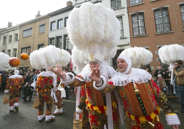Gilles of Binche throw oranges while taking part in the parade during the carnival event in Binche February 17, 2015. (Photo by Yves Herman/Reuters)