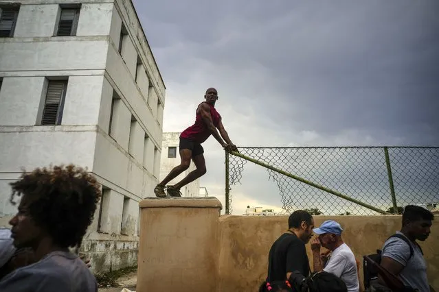 A member of Cuba's LGBTQ community dances on a wall during the annual gay pride march in support of the fight for tolerance and acceptance of the LGBTQ community in Havana, Cuba, Saturday, May 13, 2023. The march commemorates the upcoming International Day Against Homophobia and Transphobia, celebrated globally on May 17. (Photo by Ramon Espinosa/AP Photo)