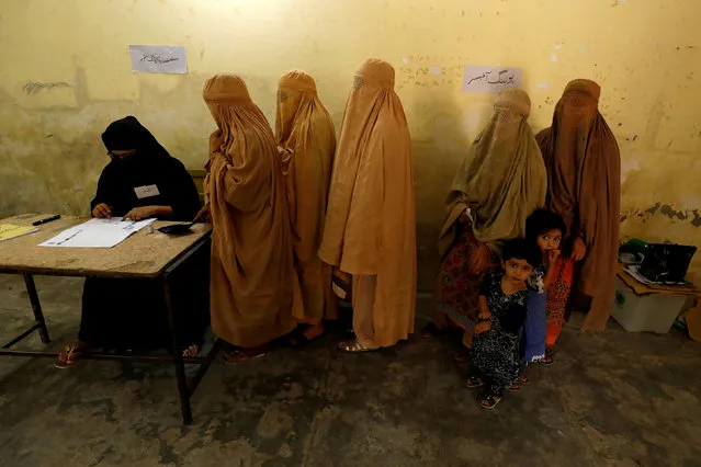 Women, clad in burqas, stand in line to cast their ballot at a polling station during general election in Peshawar, Pakistan July 25, 2018. (Photo by Fayaz Aziz/Reuters)