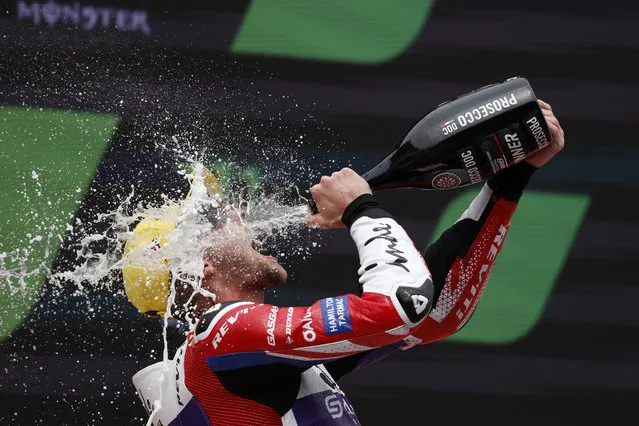 Britain's Jake Dixon sprays sparkling wine on his face as he celebrates on the podium after winning the Moto 2 race of the Catalunya Motorcycle Grand Prix at the Catalunya racetrack in Montmelo, just outside of Barcelona, Spain, Sunday, September 3, 2023. (Photo by Joan Monfort/AP Photo)
