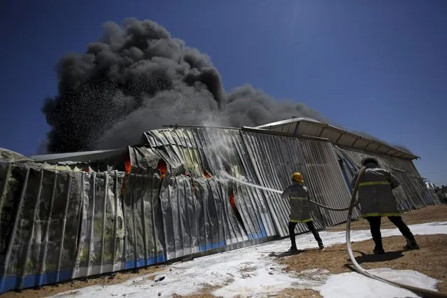 Palestinian firefighters work to extinguish a fire at a paint factory after it was hit by an Israeli airstrike, in Rafah, Gaza Strip, Tuesday, May 18, 2021. (Photo by Yousef Masoud/AP Photo)