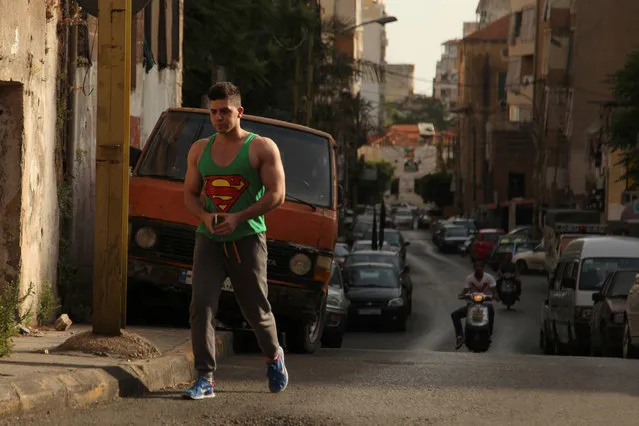 A man wearing a sleeveless shirt with the Superman logo walks along a street in Beirut, Lebanon May 2, 2016. (Photo by Alia Haju/Reuters)