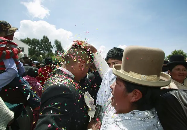 A relative puts confetti on the head of a conscript during a graduation ceremony to mark the completion of conscripts' training as soldiers under Bolivia's compulsory military service, at a barrack in La Paz, January 27, 2016. (Photo by David Mercado/Reuters)