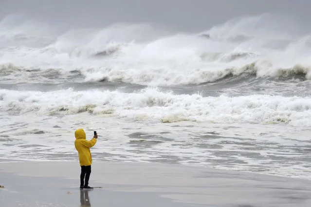 An unidentified person takes pictures of the surf and fishing pier on Okaloosa Island in Fort Walton Beach, Fla., on Wednesday, October 10, 2018, as Hurricane Michael approaches the Florida Gulf Coast. [Photo by Devon Ravine/Northwest Florida Daily News via AP Photo)