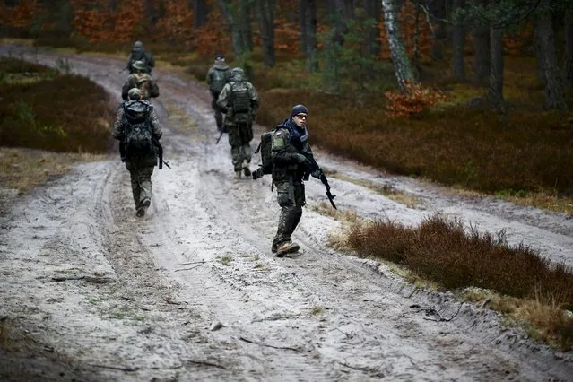 People take part in an endurance march during a territorial defence training organised by paramilitary group SJS Strzelec (Shooters Association) in the forest near Minsk Mazowiecki, eastern Poland March 14, 2014. (Photo by Kacper Pempel/Reuters)