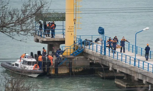 Rescuers unload fragments and remains from a boat, found at the site of the Tu-154 plane crash near Sochi, Russia, 25 December 2016. According to media reports, a Tupolev-154 Russian airplane carrying at least 92 people disappeared from radar and crashed into the Black Sea after taking off from an airport in Sochi on 25 December. The plane which was flying to Latakia, Syria, was reportedly carrying 65 members of the Alexandrov Ensemble, eight crew members, nine Russian journalists as well as Russian civil activist, Doctor Yelizaveta Glinka (Doctor Liza). (Photo by Yevgeny Reutov/EPA)