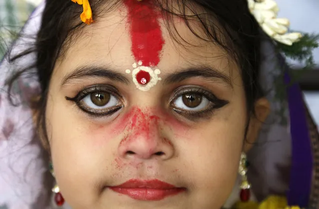 A young Hindu girl sits for a ceremony where she and other girls are worshipped as “Kumari”, or living goddess, during Ram Navami festival, at a temple in Kolkata, India, Saturday, March 28, 2015. (Photo by Bikas Das/AP Photo)