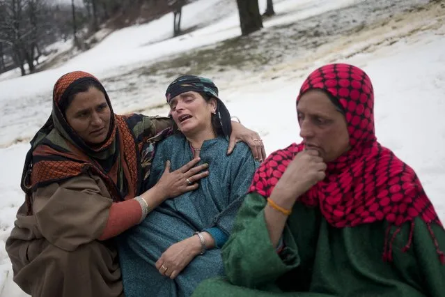 An unidentified woman, left, comforts a relative of  landslide victims in the village of Laden some 45 Kilometers (28 miles) west of Srinagar, Indian-controlled Kashmir, Monday, March 30, 2015. (Photo by Dar Yasin/AP Photo)
